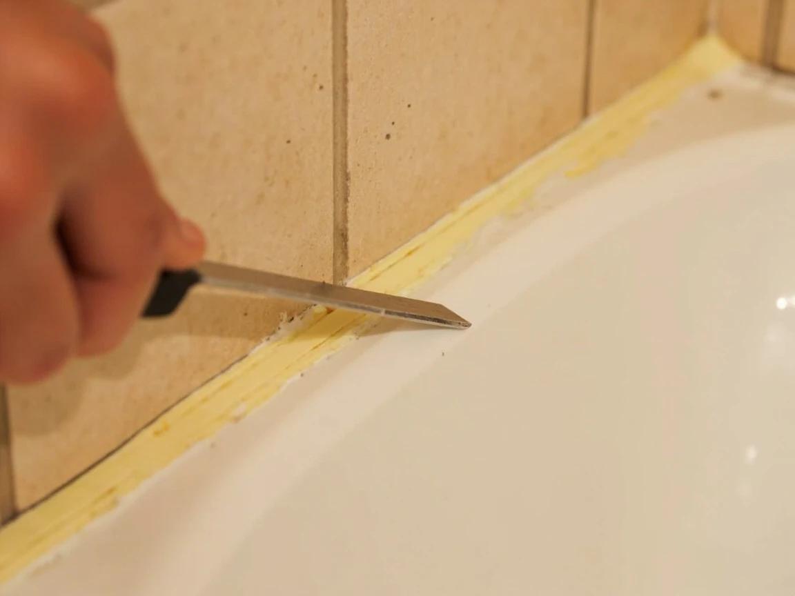Step 2 of How to Re-Caulk a Bathtub or Shower Surround: Cut and pull out the old caulk completely